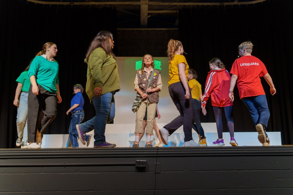 High school students dance around Cady as she sings “It Roars”.